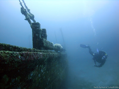 Diver Bruce swimming along the port side of Coral Canyon Wreck, Pemuteran, Bali