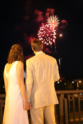 Couple holding hands watching fireworks during their wedding at the Harbor Lights room