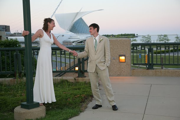 John and Ellie holding hands outside with the Calatrava Art Museum as a backdrop