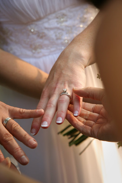 Guests looking at wedding ring on bride's hand