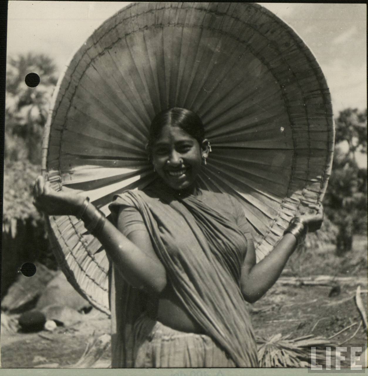 An Indian Lady is Holding a Canopy