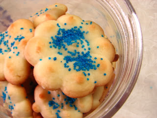 Flower shaped shortbread cookies with blue sprinkles