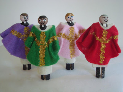 Priest peg dolls lined up in different colored robes
