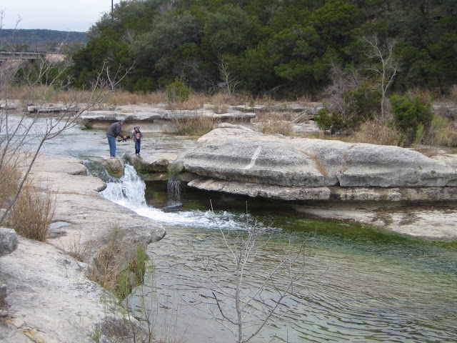 fast flowing creek with people standing next to it