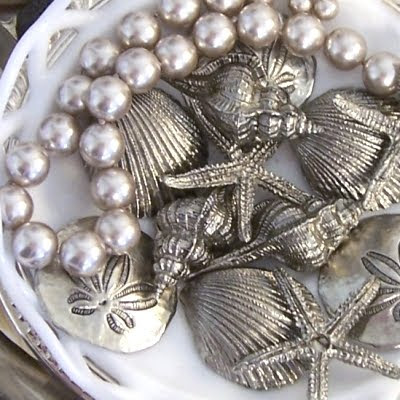 display silver starfish and shells in bowl