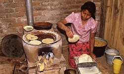 A color photo of a Central-American woman making tortillas circa 1990.