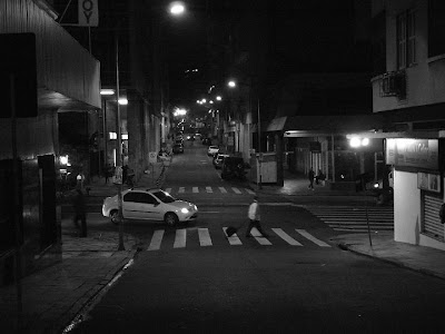 pedestre atravessando a Rua Jerônimo Coelho na faixa de segurança à noite em Porto Alegre, enquanto veículo espera o pedestre, trânsito, foto preto e branco, fotoblog de Porto Alegre