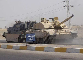 A broken-down Challenger being towed by a tank recovery vehicle