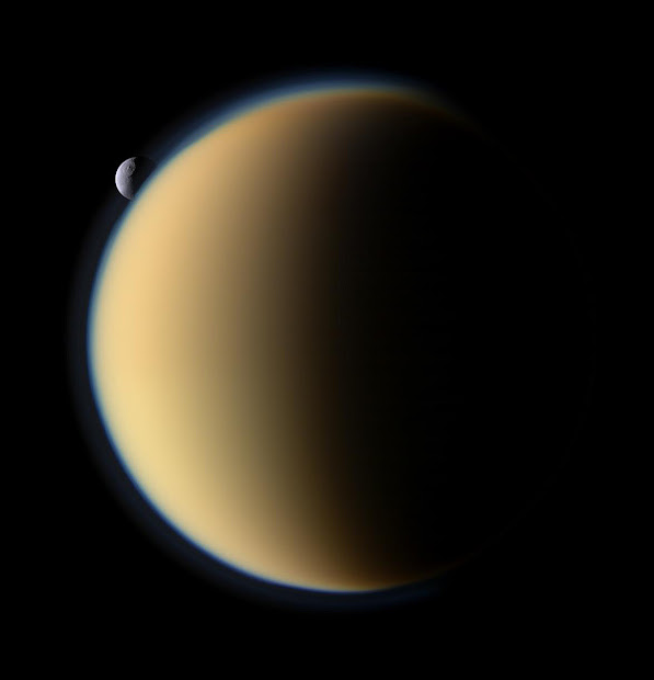 Saturn's moon Tethys with Odysseus crater slips behind Titan