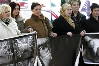 Relatives of Srebrenica victims hold photos relating to the massacre as they prepare to leave Sarajevo in Bosnia early Saturday, Feb. 24, 2007 for the Netherlands to attend Monday's verdict by the International Court of Justice in a genocide case against Serbia and Montenegro in the Hague.