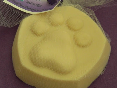 Picture of a bar of goat milk soap - which has a puppy paw shape on the top