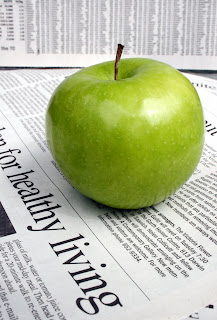 newspaper article and green apple