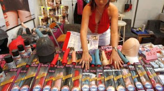 Woman displaying sex toys.