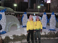 cute kids posing in front of geographically-confused light sculpture with penguins AND polar bear, igloo