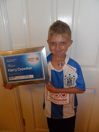 Harry with his Examiner Community Courage Award and T-shirt from Huddersfield Town Football Club