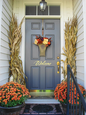 fall front porch with corn stalks and pumpkins