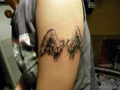 Two angel wings tattoo on the arm.