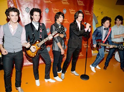 The Jonas Brothers pose with wax replicas at Madame Tussauds Wax Museum in Washington, D.C. - Photo courtesy of Getty Images/Paul Morigi and E!Online