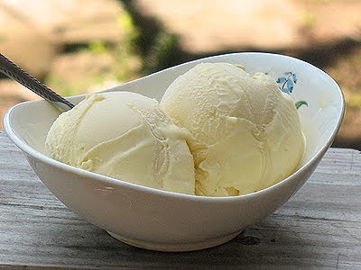 Een close up van twee bolletjes witte chocolade-ijs in een witte kom.