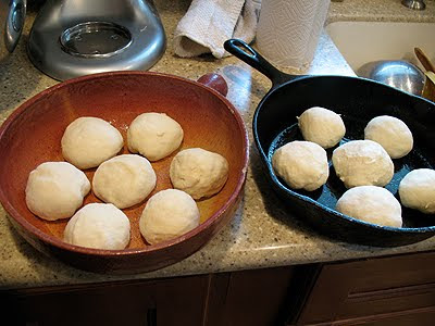 A photo of homemade dinner roll dough in two cast iron skillets.