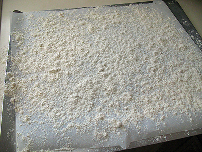 A photo of a baking sheet lined with parchment paper and sprinkled generously with flour.