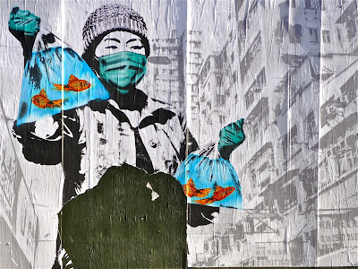 photo of street art in which an apparently Chinese woman is carrying bags of goldfish with a background that appears to be Hong Kon